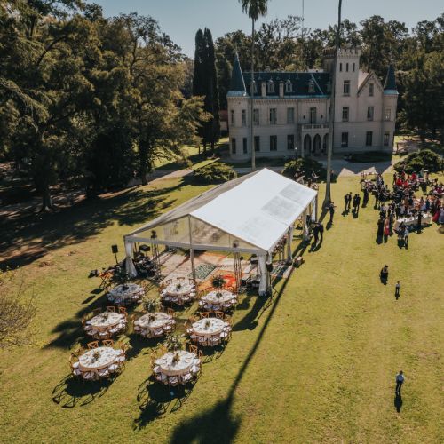 Evento social con carpa y mesas en los jardines de una estancia